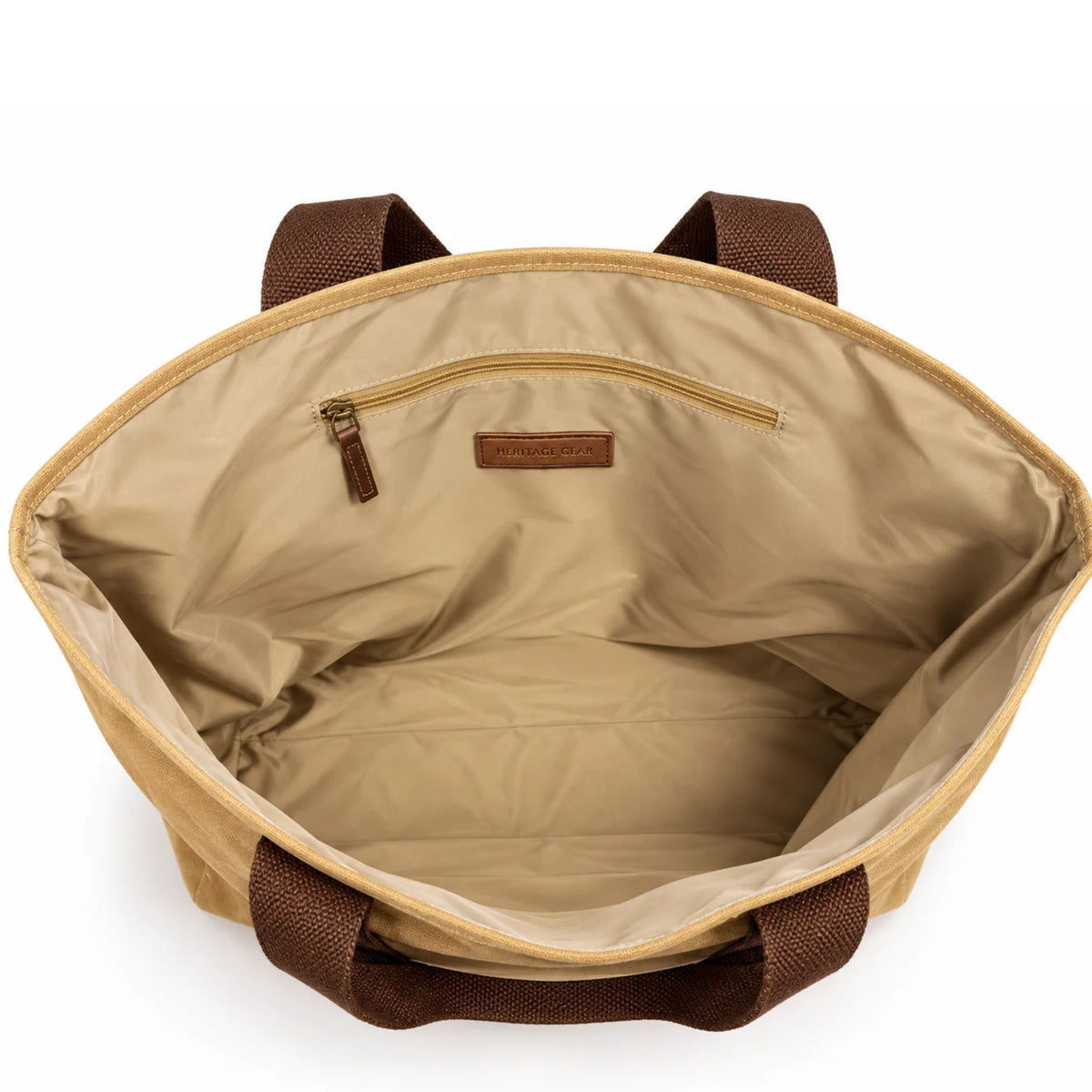 Interior view of the tan Air Force Academy canvas boat tote showing beige lining, zippered storage pocket, and brown cotton handles.