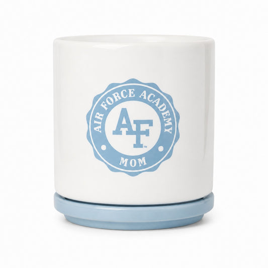 White ceramic Air Force Academy Mom planter with a cloud blue drainage plate featuring the Air Force Academy Mom emblem.