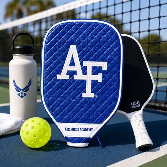 Air Force Academy quilted pickleball paddle cover with embroidered AF logo, white piping, velour-lined interior, and full-length zipper.