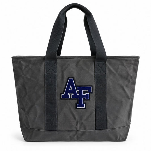 Front view of the charcoal Air Force Canvas Boat Tote featuring a blue and white chenille AF logo, sturdy black handles, and structured canvas design.