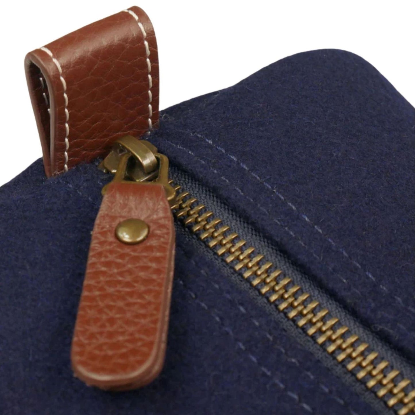 Close-up of the Air Force Wool Dopp Kit’s brass zipper, brown pebbled leather pull, and snap-down end tab.