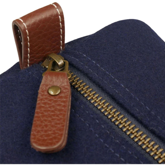 Close-up of the Air Force Wool Dopp Kit’s brass zipper, brown pebbled leather pull, and snap-down end tab.