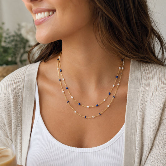 Gold-tone double strand beaded necklace with alternating royal blue and white beads