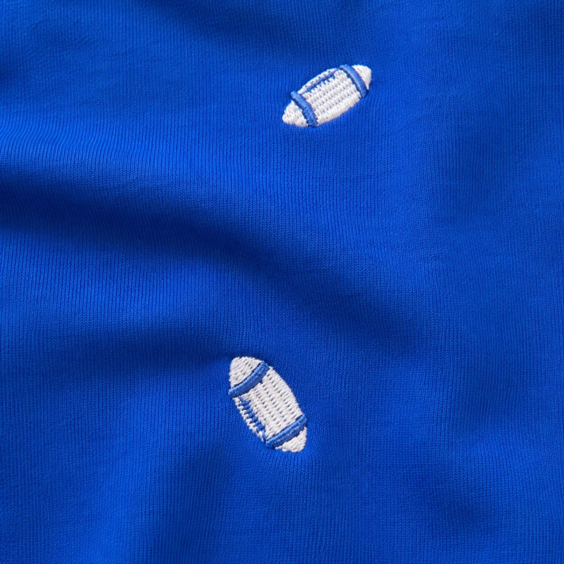 Woman wearing the Air Force blue Football Season Embroidered Blouse with allover white football embroidery