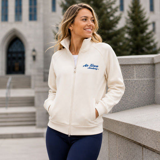 Women's Air Force Academy full-zip jacket in cream scuba knit fabric featuring embroidered blue script logo, raglan sleeves, and front pockets.