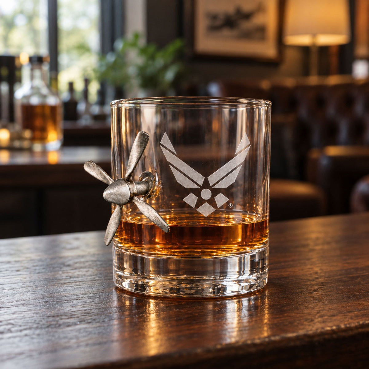 Air Force old fashioned glass with a silver propeller and a pour of whiskey on a bar